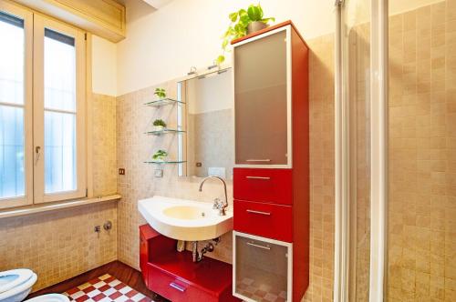 a bathroom with a sink and a red cabinet at Dream House in Bergamo