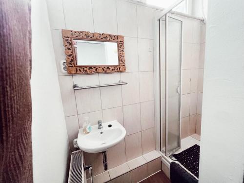 a bathroom with a sink and a shower at Linden Apartment Wolfenbüttel in Wolfenbüttel