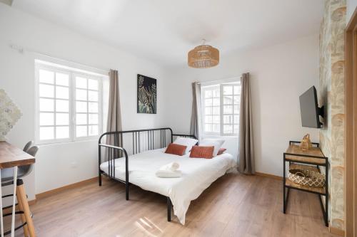 a bedroom with a bed and two windows at Les Petits Pavillons Standing Clim Vieux-Port - MaisonMars in Marseille