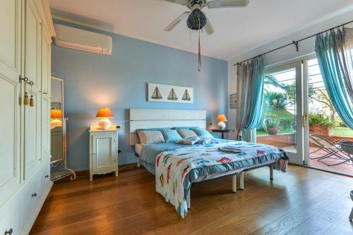 una camera da letto con letto, pareti blu e pavimenti in legno di Elba Offsite Villa a Capoliveri