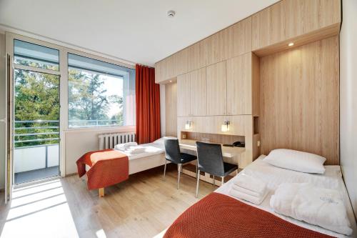 a hotel room with two beds and a desk at ESTONIA Medical Spa & Hotel in Pärnu