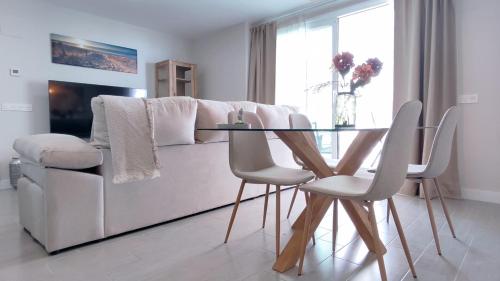 a living room with a white couch and a glass table at Dunas Beach II Apartment in Torrox Costa