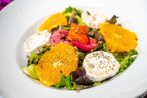 a salad with oranges and other vegetables in a white bowl at Agroturismo Son Siurana in Alcudia