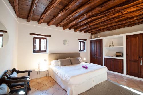 ein Schlafzimmer mit einem weißen Bett und einer Holzdecke in der Unterkunft Elegant Ibizan Finca Modern and Classic Features Finca Aleece Santa Gertrudis in Santa Gertrudis