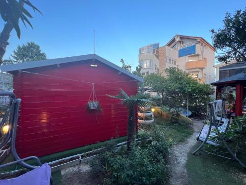 a red building with a fence next to a building at Apartments and bungalows vila Dalibor in Nin