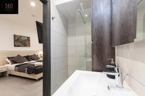- une chambre avec un lit et une salle de bains pourvue d'une douche dans l'établissement Modern, Large and Spacious HOME, Perfect for GROUP by 360 Estates, à Msida