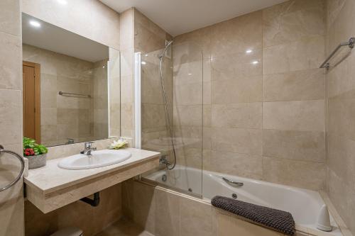 uma casa de banho com um lavatório, um chuveiro e uma banheira em Precioso apartamento de planta baja en Las Salinas, Estepona em Estepona