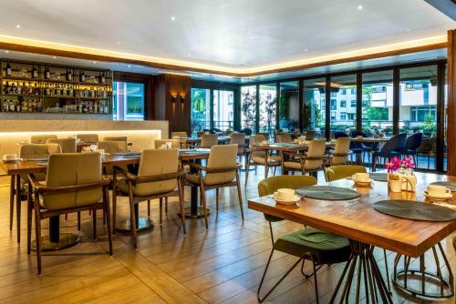 un restaurante con mesas y sillas de madera y ventanas en Tzl Suites Hotel Nişantaşı en Estambul