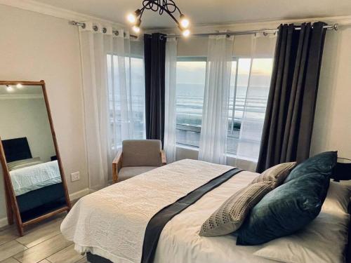 sypialnia z dużym łóżkiem i dużym oknem w obiekcie Luxurious 2-bedroom beach apartment with a view! w mieście Bloubergstrand