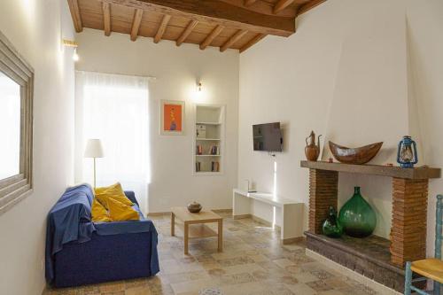 uma sala de estar com um sofá azul e uma lareira em Casa Gli Olmi - centro storico em Bracciano