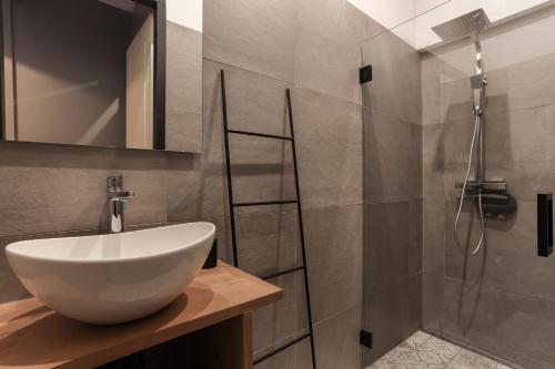 ein Badezimmer mit einem weißen Waschbecken und einer Dusche in der Unterkunft ZEEenMEER in Kamperland