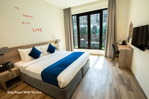 a bedroom with a large bed and a large window at Grand Kingsgate Jaddaf Waterfront Hotel by Millennium in Dubai