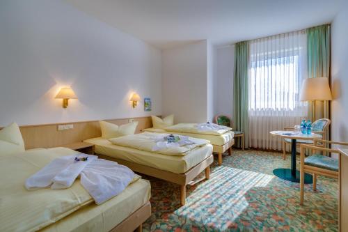 Habitación de hotel con 2 camas y mesa en Hotel Astor en Altemburgo