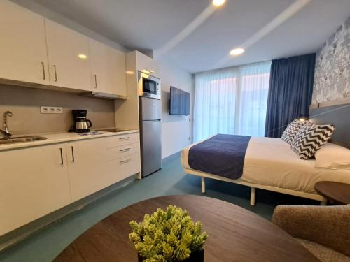 a hotel room with a bed and a kitchen at RK Farallón Canteras in Las Palmas de Gran Canaria