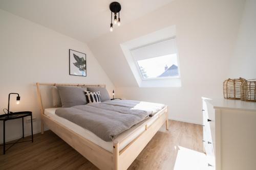 a bed in a white room with a window at Moderne Küstenbutze in Nordseenähe (Butze #3) in Mildstedt
