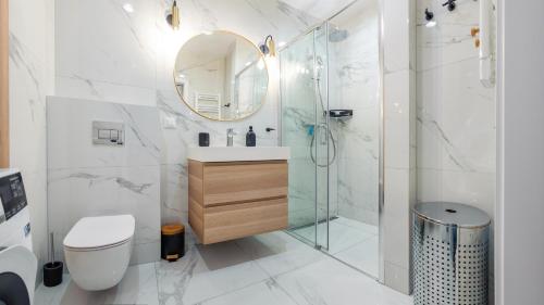 a bathroom with a shower and a sink and a mirror at Bursztynowe Osiedle Jantar, Sun & Snow in Jantar