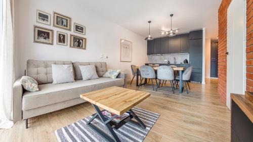 a living room with a couch and a table at Bursztynowe Osiedle Jantar, Sun & Snow in Jantar