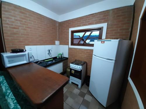 een kleine keuken met een witte koelkast en een tafel bij Casa Recanto da Serra in Conceição da Ibitipoca