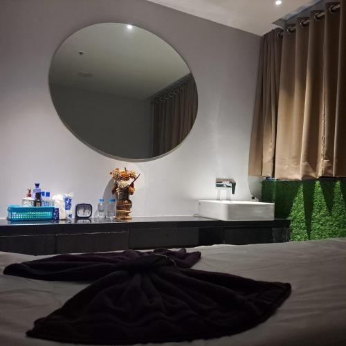 ein Schlafzimmer mit einem großen Spiegel und einem Waschbecken in der Unterkunft Devka Beach Resort in Daman