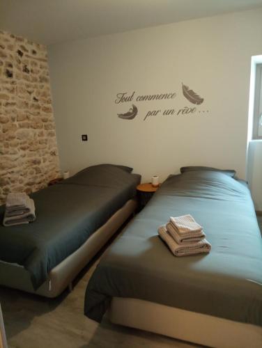 two beds sitting next to each other in a room at La poule aux oeufs dort in Soudan