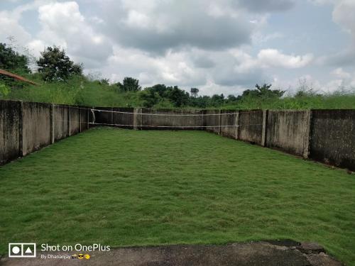 a large field of grass next to a fence at Chalet Ahaz, the place of privacy with outside sitting in Karjat