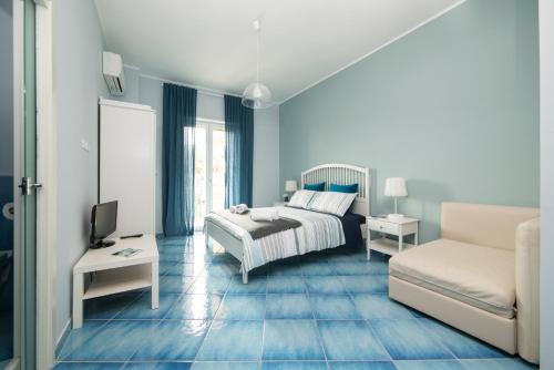 a blue bedroom with a bed and a couch at CAPRI B&B in Salerno