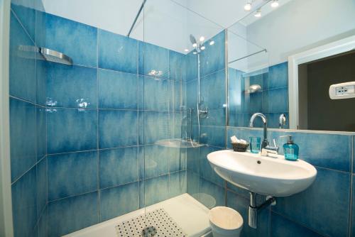 サレルノにあるCAPRI B&Bの青いタイル張りのバスルーム(洗面台、トイレ付)