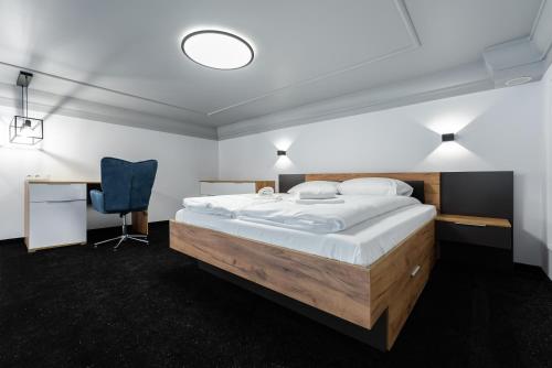 um quarto com uma cama grande e uma cadeira azul em Apartamenty Centrum nowoczesny design - Dream Apart em Bielsko-Biala