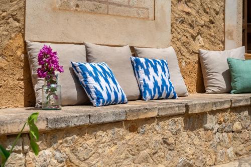 a bench with pillows and a vase of flowers on it at Agroturismo Son Siurana in Alcudia