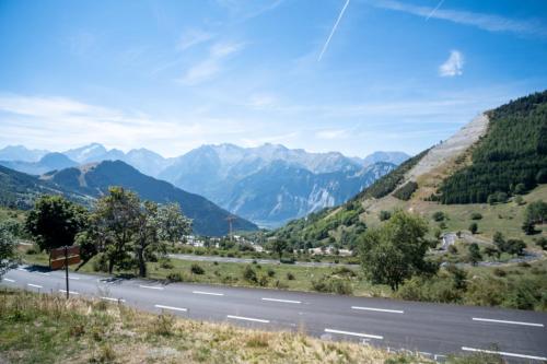 una autopista con montañas en el fondo en Studio with balcony and beautiful view - Alpe d'Huez - Welkeys en LʼHuez