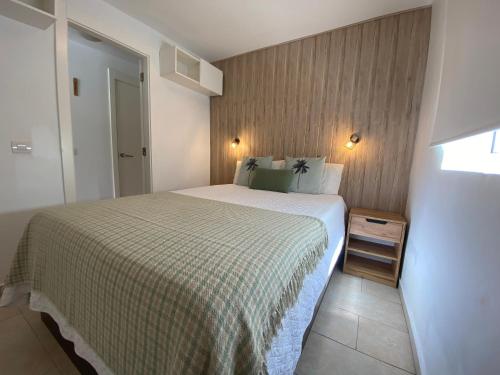 ein Schlafzimmer mit einem Bett mit einer grünen und weißen Decke in der Unterkunft Apartamento relax Tauro in Mogán