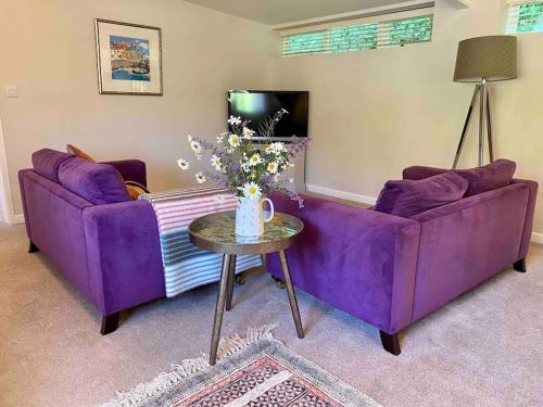 fioletowa kanapa i stół w salonie w obiekcie Little Innsacre w mieście Bridport