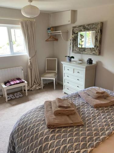 a bedroom with a bed with towels on it at Little Innsacre in Bridport