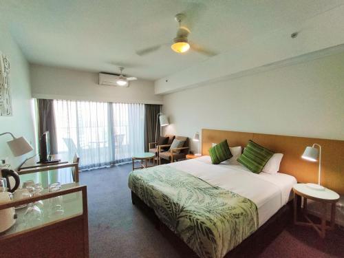 ダーウィンにあるDarwin Harbour Suiteの大きなベッドとデスクが備わるホテルルームです。