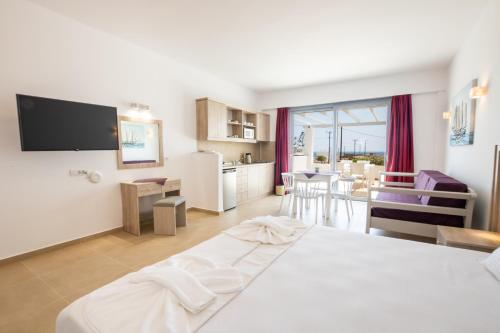 pokój hotelowy z dużym łóżkiem i kuchnią w obiekcie Bella Karpathos Villas w mieście Karpatos