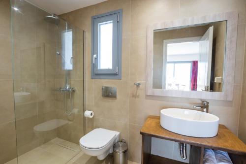 a bathroom with a sink and a shower and a toilet at Bella Karpathos Villas in Karpathos