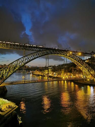 a bridge over a river with a train on it at Bridge It - Suites & Views in Vila Nova de Gaia