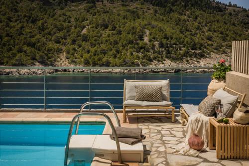 a patio with a pool and chairs next to a mountain at Braunis Horio Villas in Asos