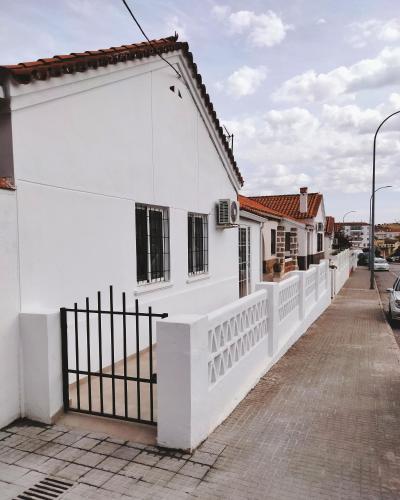 a white house with a fence and a sidewalk at Apartamento Ceclavín in Cáceres