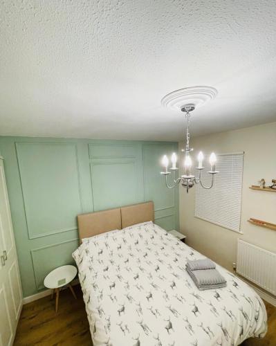 a bedroom with a bed and a chandelier at Entire Home between London and Kent- Mulberry House in Kent