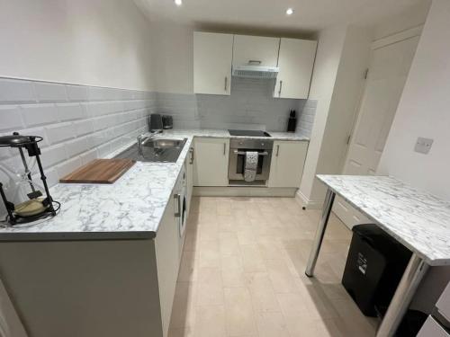 a white kitchen with a sink and a counter at Lovely 1 Bedroom Apartment - Maida Vale London in London