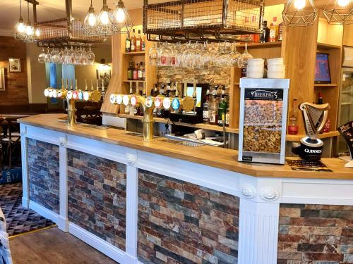 a bar in a restaurant with a brick wall at The Railway Crossings in Wingate