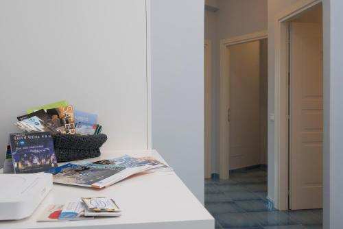 a room with a table with magazines and a mirror at CAPRI B&B in Salerno