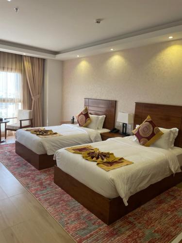 um quarto de hotel com duas camas num quarto em Alsahwa Hotel em Seeb