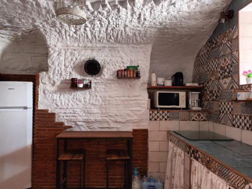 eine Küche mit einer Theke und einer weißen Wand in der Unterkunft Cuevas Baza in Baza