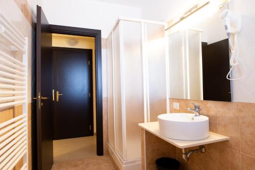 een badkamer met een wastafel en een spiegel bij G&G Hotel in Grammichele