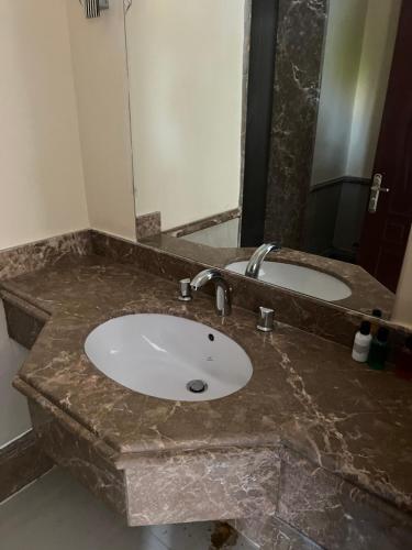 ein Badezimmer mit einem Marmorwaschbecken und einem Spiegel in der Unterkunft Palm resort 2B in Sharm El Sheikh