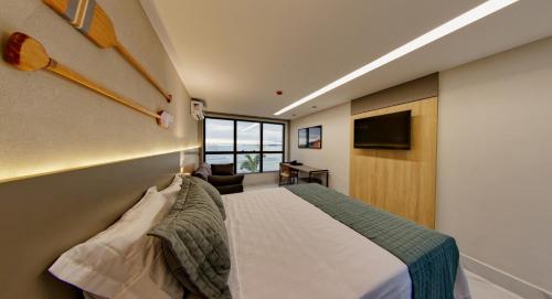 a hotel room with a bed and a television at Gaeta Hotel in Guarapari