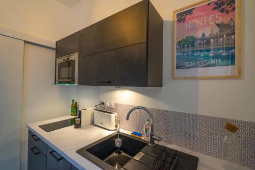 un comptoir de cuisine avec un évier et un micro-ondes dans l'établissement Marechal's Studio near train station & downtown, à Nantes