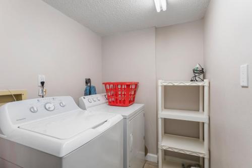 a laundry room with a washing machine and a basket at 104 Las Brisas Condo in St Pete Beach